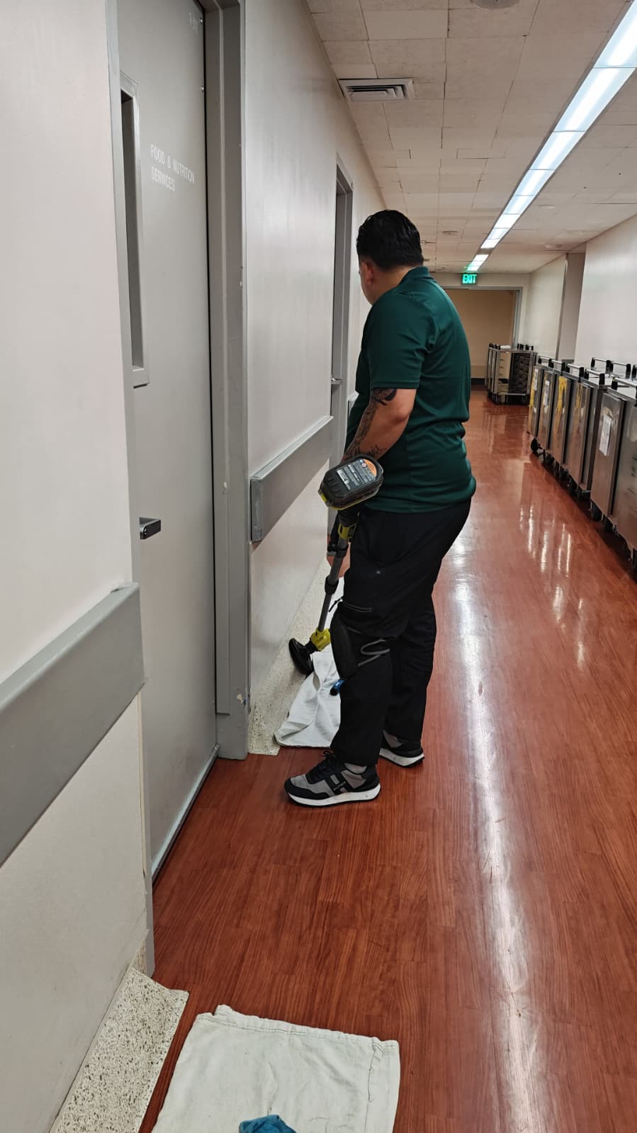 R Megal technician detailing floor along corridor
